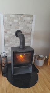 a black stove in a room with a brick wall at Ferienhaus Lena am Silbersee in Frielendorf