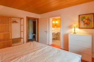 a bedroom with a bed and a bathroom at Unter den Reben in Niederkirchen bei Deidesheim