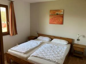 um quarto com duas camas e um quadro na parede em Ferienhaus Lena am Silbersee em Frielendorf
