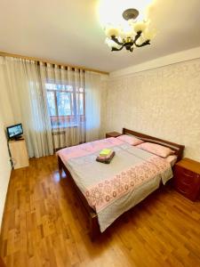 a bedroom with a bed and a chandelier at Квартира на Воскресенці, поруч метро Лівобережна, Інститут Серця, МВЦ in Kyiv