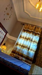 a bedroom with a bed with a yellow and blue blanket at RAMS ENG ROME appartement meublé in Douala