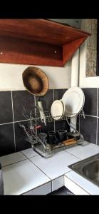 a drying rack with plates and pans in a kitchen at RAMS ENG ROME appartement meublé in Douala