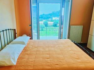 Cama en habitación con ventana grande en Casa Grottammare-Sea Relax Holiday Home-, en Grottammare