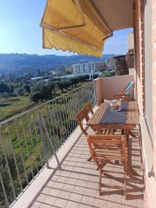 balcón con mesa, sillas y sombrilla en Casa Grottammare-Sea Relax Holiday Home-, en Grottammare