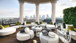 a rooftop patio with white furniture and a view of the city at SAWA 6 metro fast WiFi 70'TV panorama HBO, Netflix, Dsiney+ in Warsaw