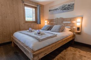 a bedroom with a large wooden bed in a room at LE TOI DU MONDE in Flumet