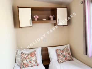 a bedroom with a bed and two pillows at Homely 3 bed - Sleeps 8 @ Seal Bay, Selsey in Chichester