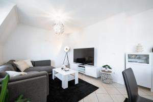 uma sala de estar com um sofá e uma televisão em Modern Penthouse in Sanem em Sanem