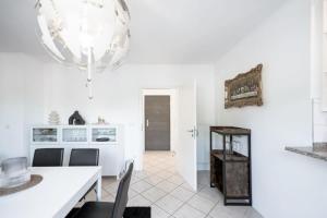 cocina con paredes blancas, mesa y sillas en Modern Penthouse in Sanem, en Sanem
