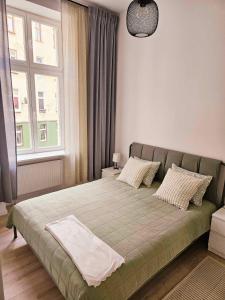 1 cama en un dormitorio con ventana grande en Justinrent 2, en Legnica