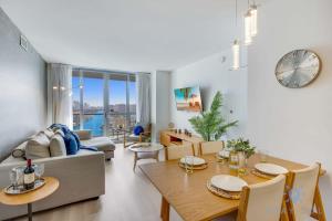 sala de estar con mesa, sofá y reloj en Amaizing Pool Infinity View w Balcony Gym, en Hallandale Beach