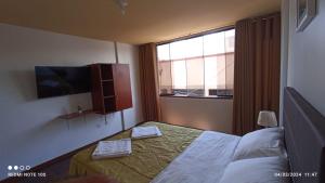 ein Hotelzimmer mit einem Bett und einem Fenster in der Unterkunft Montecristo Hotel in Tacna