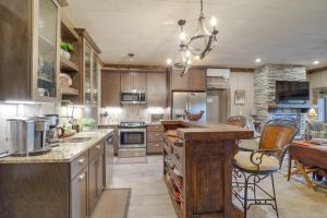 a large kitchen with wooden cabinets and a table at 1 Mi to Beech Mtn Cabin with Fire Pit and BBQ! in Beech Mountain
