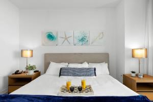 a bedroom with a bed with two candles and two lamps at Infinite View and Balcony with Pool, Gym, Near Beach in Hallandale Beach