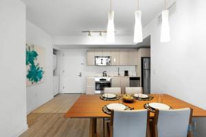 a kitchen and dining room with a wooden table and chairs at Infinite View and Balcony with Pool, Gym, Near Beach in Hallandale Beach