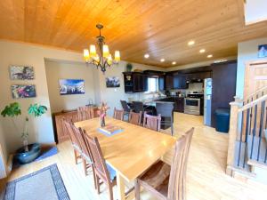 a dining room and kitchen with a wooden table and chairs at Morrisey Chalet at Sun Peaks in Sun Peaks