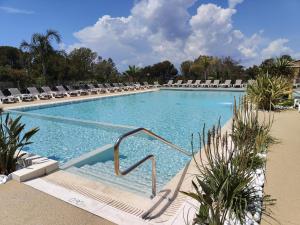 una gran piscina con tumbonas en un complejo en BUNGALOW DOMAINE DE L'ILE D'OR, en Saint-Raphaël