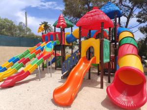 un parque infantil con una fila de juegos coloridos en BUNGALOW DOMAINE DE L'ILE D'OR, en Saint-Raphaël