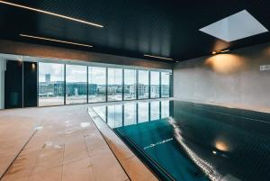 una piscina in un edificio con una grande finestra di Stylish and Luxurious Apt with Pool & Gym ID214 a Lussemburgo