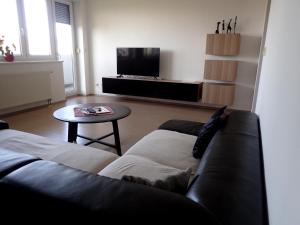 a living room with a couch and a table at Marguerite apartment - parking including in Bratislava