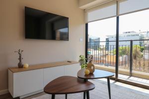 a living room with a tv and a table at Amazing 1BR with modern balcony in San Isidro in Lima