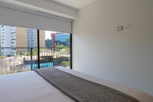 a bedroom with a bed and a large window at Amazing 1BR with modern balcony in San Isidro in Lima