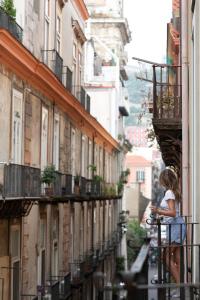 una donna in piedi su un balcone di un edificio di Santa Chiara Boutique Hotel a Napoli