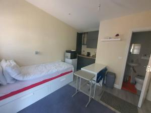 a room with a bed and a desk and a kitchen at Private Ensuite Room with Kitchenette in Phibblestown