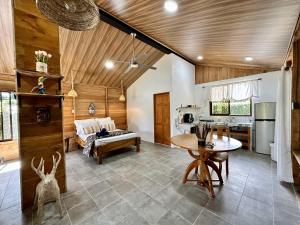 een woonkamer met een tafel en een keuken bij Romantic Private Cabin in the Forest, Bungalows Tulipanes in San Ramón