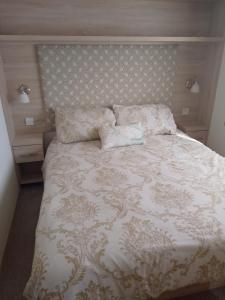 a bedroom with a bed with a white comforter at Seasalter Cosy Caravan, in Seasalter