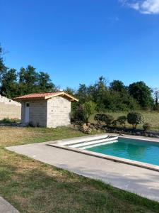 una piscina junto a una casa con un edificio en Du coté de chez Flo, en Bazas