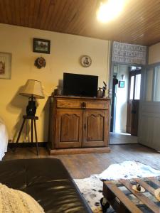 a living room with a tv on a wooden entertainment center at Le pigeonnier maison de caractère logement 4 personnes La maisonnette rénovée logement 2 personnes in Floirac