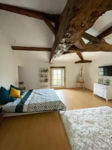 een grote slaapkamer met een bed en een houten plafond bij Du coté de chez Flo in Bazas