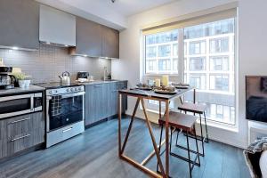 a kitchen with a table and a stove top oven at Cozy Suite in Heart of Downtown Toronto J7 in Toronto