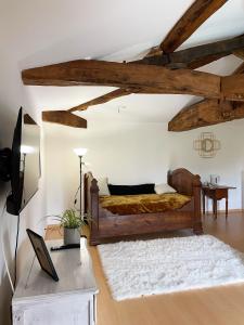 een slaapkamer met een bed in een kamer met houten balken bij Du coté de chez Flo in Bazas