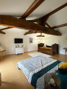 a bedroom with a large bed in a room with wooden ceilings at Du coté de chez Flo in Bazas