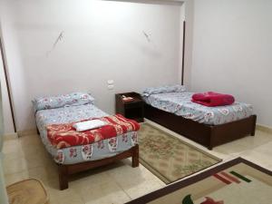 2 Betten und ein Sofa in einem Zimmer in der Unterkunft Ali habou Wassersport in Luxor