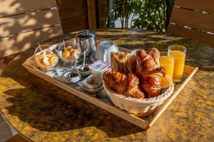 a tray of bread and croissants on a table at Residence Melody - Adult only in Saint-Rémy-de-Provence