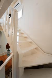 eine weiße Treppe in einem Haus mit Fenster in der Unterkunft AFFITTACAMERE ANEMONE- SCIROCCO1 in Uggiano la Chiesa