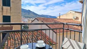 een tafel op een balkon met uitzicht op de gebouwen bij Sky Apartment by Casa in mente in Cefalù +13 foto's