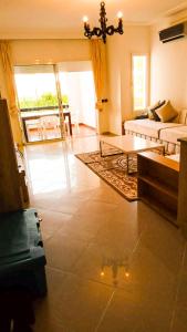 - un salon avec un canapé et une table dans l'établissement Appart 2 chambres à Asilah Marina Golf, à Assilah