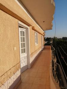 a balcony of a building with a white door at Ali habou {4} in Luxor