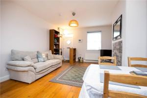 a living room with a couch and a table at Super 2-Bed House 5 min to Harcourt Tram Stop in Dublin