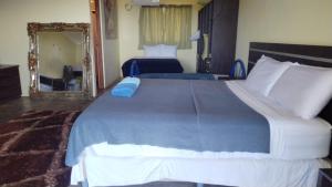 1 dormitorio con 1 cama grande y espejo en Hotel El Sol Morrillo, en Los Duarte