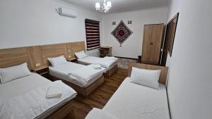 Habitación de hotel con 2 camas y ventana en HOTEL MEHRIBON, en Samarkand