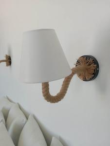 a lamp with a white lamp shade on a wall at Seascape, apartment with sea view 1 in Áno Meriá
