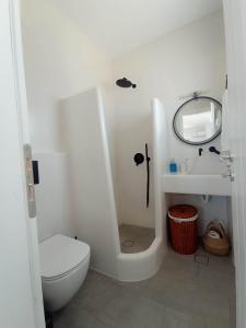 a white bathroom with a toilet and a sink at Seascape, apartment with sea view 1 in Áno Meriá