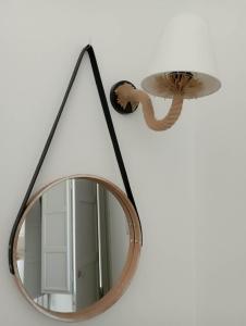 a mirror hanging on a wall next to a lamp at Seascape, apartment 1 with sea view in Ano Meria