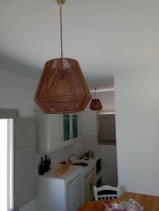 une cuisine avec une lampe pendant sur un comptoir dans l'établissement Seascape, apartment 1 with sea view, à Áno Meriá