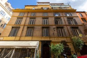 a tall brick building with windows and a balcony at The Romulus in Rome